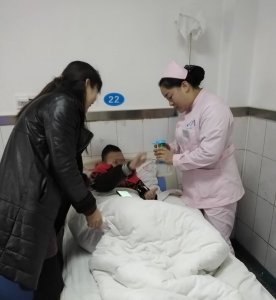 护士刘巍为喜欢画画的小患者送来画笔